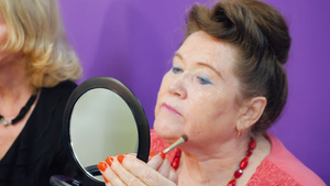 老妇人照镜子用化妆刷化妆19秒视频