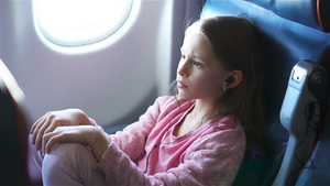 可爱的小女孩乘飞机旅行可爱的孩子坐在飞机的窗户附近30秒视频