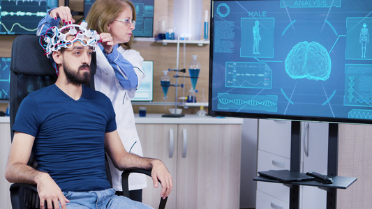 男性患者在脑部阅读大脑活动时头顶上戴现代技术的男性视频