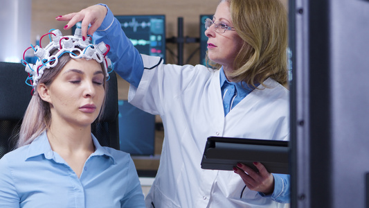 女医生从病人耳机上检查传感器的多利射击视频