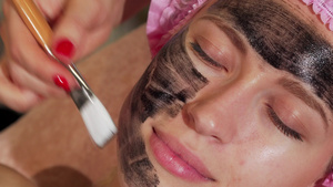美容师在女性面部涂抹洁面泥9秒视频