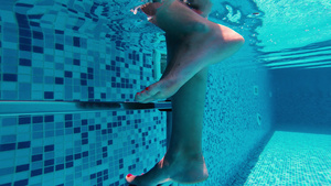 水下的女子腿在游泳池中爬上金属梯子9秒视频