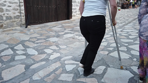 妇女用拐杖在人行道上走路15秒视频