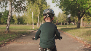 小孩在阳光明媚的秋天骑自行车背影19秒视频