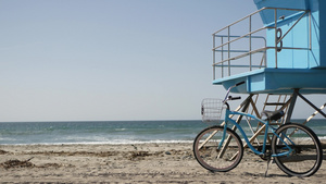 海滨加里弗尼亚海岸夏季海滨救生塔旁的单车16秒视频