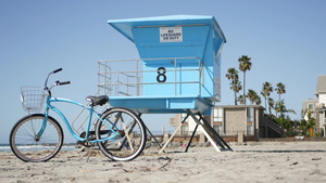 海滨加里弗尼亚海岸夏季海滨救生塔旁的单车15秒视频
