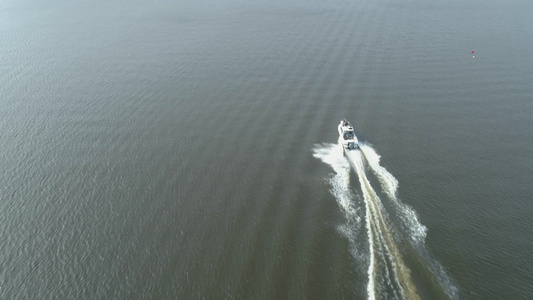豪华快艇在阳光明媚的日子驶入海湾鸟瞰图揭示射击无人机视频