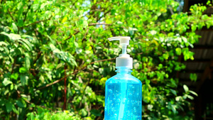 在花园中缓慢横穿蓝色凝胶瓶和模糊绿树15秒视频
