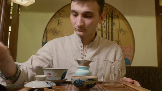 茶叶师傅在仪式上将热水从酒壶倒到鱼湾用于泡茶视频