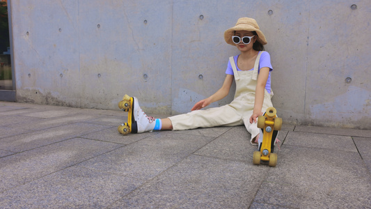 年轻女孩戴着帽子和墨镜坐在空地上休息视频