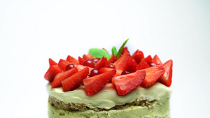 缓慢旋转的草莓和薄荷装饰的美味蛋糕与白种背景隔绝的31秒视频