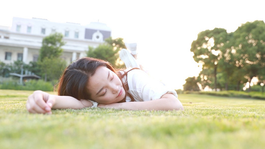 夕阳下青春大学生躺在草地上视频