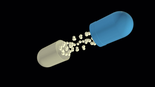药丸打开并显示内容物没有背景飞行蓝色和白色药丸的慢动作视频
