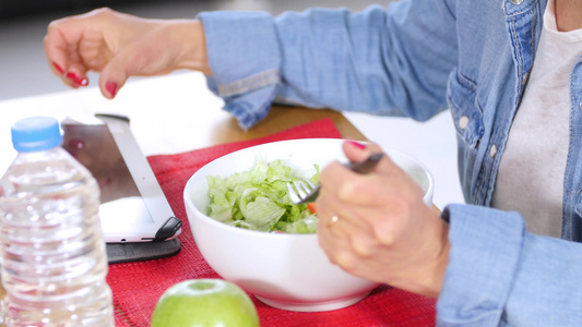 女性在吃沙拉时使用数字平板片紧紧手视频