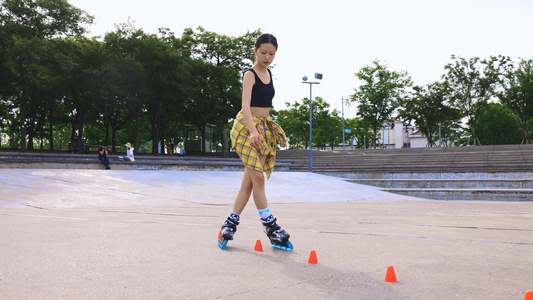 年轻女孩在空地上利用障碍物练习花式轮滑视频
