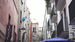 蓝雨伞和纹身工作室的巷子向后移动6秒视频