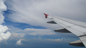 一架飞机在白云和蓝天上空飞行的机翼14秒视频