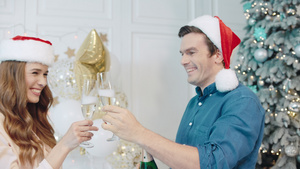 在圣诞树附近喝香槟的一对幸福情侣25秒视频