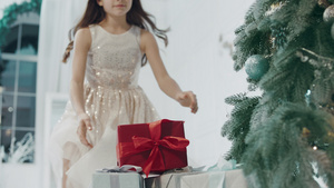 快乐女孩在现代公寓的圣诞树附近 拿着礼物盒10秒视频
