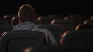 一名男子坐在空的电影厅13秒视频