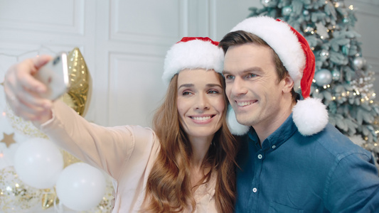 微笑的情侣在圣诞树附近自拍视频