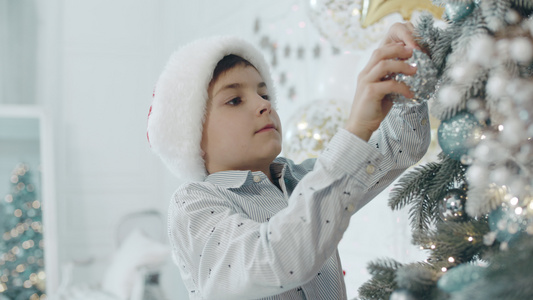 在客厅装饰圣诞树的男孩视频