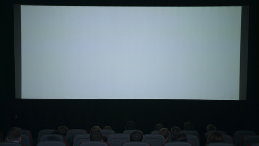 观众鼓掌期待在白屏幕前观看电影视频