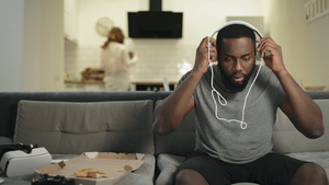 惊异的黑人在家中厨房用耳机听音乐29秒视频