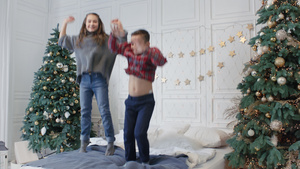 圣诞节两个笑着的青少年在豪华宅里跳床29秒视频