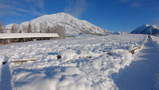 新疆冬季旅游禾木雪山蓝天白雪行走视角拍摄视频