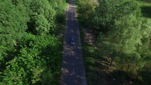 通过夏季森林空中观察在农村公路上行驶的汽车22秒视频