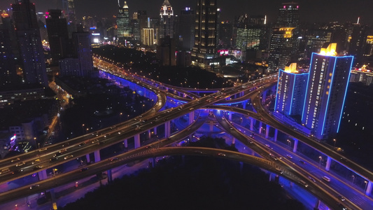 夜间高架立交桥与蓝色照明和上海城市景观。中国。鸟瞰图。无人机向上飞行，相机向下倾斜视频