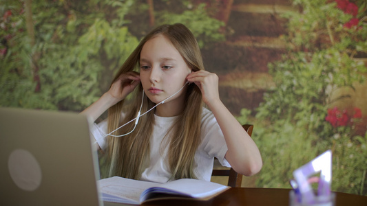 戴耳机看笔记本电脑的年轻女孩视频
