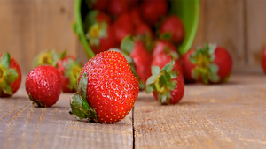 新鲜草莓从木桶上落在木桌上的慢动作镜头28秒视频