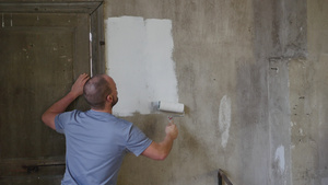 真正的专业房屋画家站在画一堵灰色的墙上的背影53秒视频