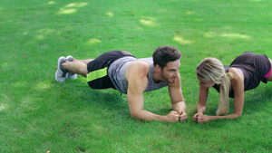快乐的男女在户外健身训练中 站在绿草木板上18秒视频