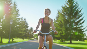 享受骑自行车和在夏季公园挥手的快乐妇女17秒视频