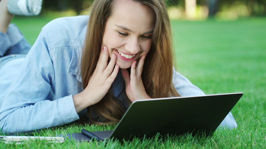 快乐的女士在公园笔记本电脑上看到有好消息的电子邮件视频