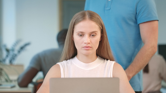 男性手按摩女青年,在工作时用笔记本电脑工作视频