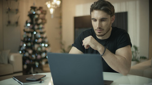 男子在圣诞节树上使用笔记本电脑14秒视频