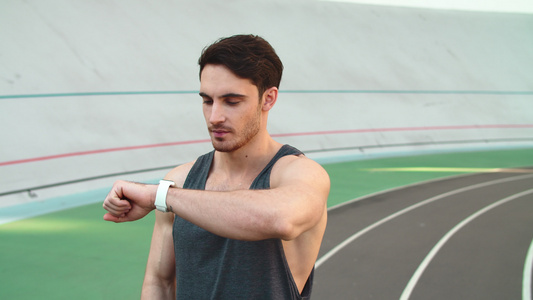 在跑道上运用智能手表的运动员肖像视频