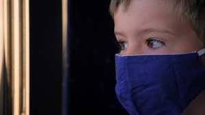 一个戴着口罩的男孩望着火车窗外24秒视频