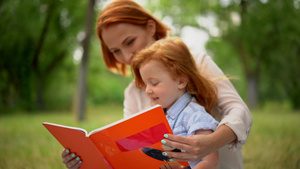 快乐的年轻母亲与女儿一起在户外阅读30秒视频