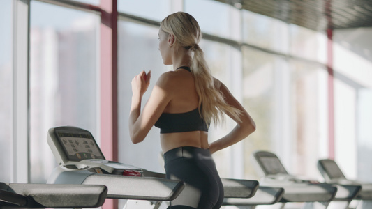 在健身房运动机上练习的女跑步妇视频