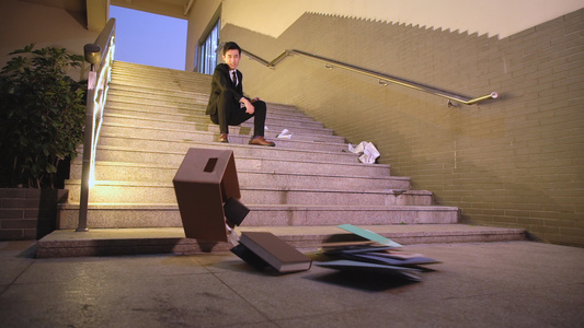 失业的白领坐在楼梯上扔东西发泄[工人失业]视频