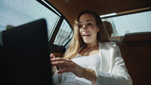在豪华汽车的笔记本电脑上欢欣鼓舞的商业女人30秒视频