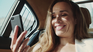 在豪华现代汽车的智能手机上友好的女商人在视频电话中微笑25秒视频