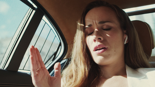 焦虑的商业女人肖像在商业车里用耳机在电话上争吵视频