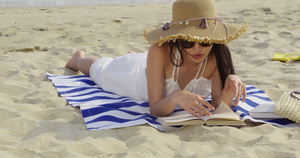 8K戴墨镜女性沙滩上看书33秒视频