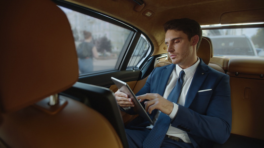 职业男性在现代汽车里使用平板电脑视频
